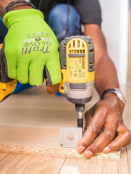 Fixguru furniture assembly expert drilling an IKEA L-bracket into place during a home renovation project.