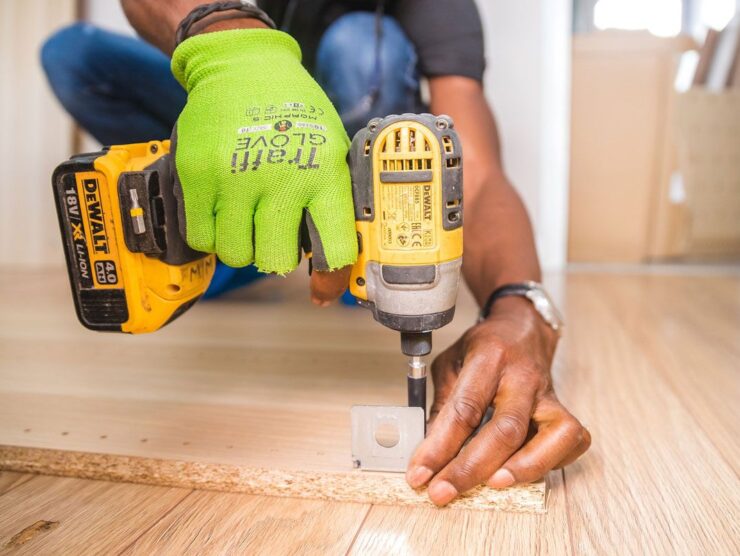 Fixguru furniture assembly expert drilling an IKEA L-bracket into place during a home renovation project.