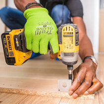 Fixguru furniture assembly expert drilling an IKEA L-bracket into place during a home renovation project.
